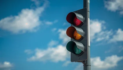 Traffic signal showing red light featuring yellow and green unlit, set against the bright blue sky with scattered clouds, captured within daylight from a low angle perspective © viperagp