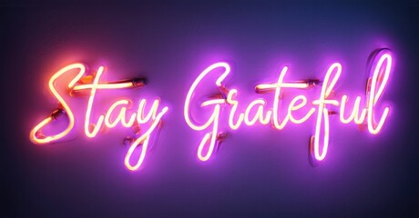 Bright pink neon sign displays Stay Grateful against dark purple wall. Inspiring message, modern aesthetic, simple design.