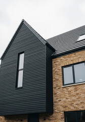 Modern architecture contrasting dark cladding and brick facade