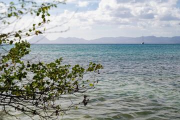 Panoramic sea view with a sailboat on the horizon under a bright sky