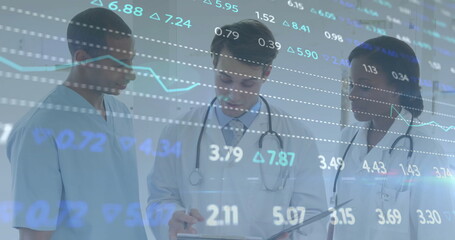 Reviewing projected charts in clinic team wearing lab coats and stethoscopes holding clipboard