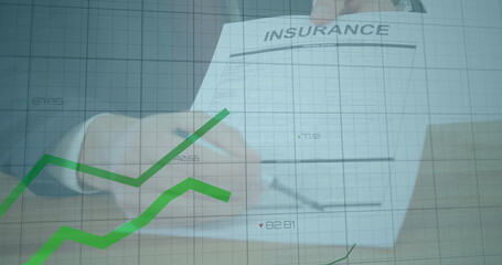 Signing suited hand holding pen and filling insurance form at office desk showing green data grid