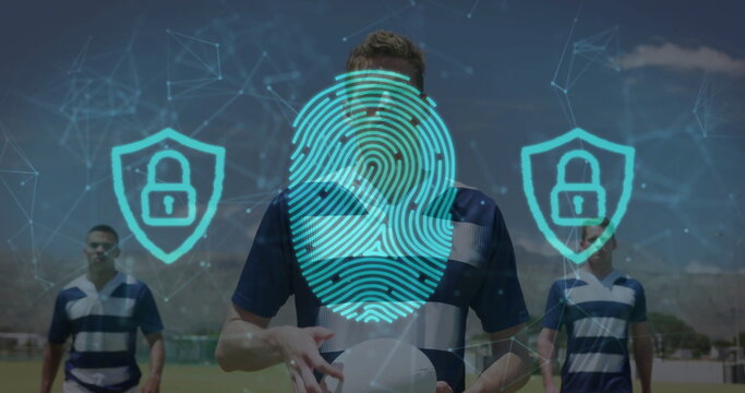 Standing striped jersey athlete holding ball on grass projecting digital security icons