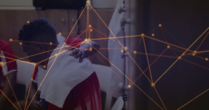 Sitting athlete in jersey draping towel, teammate offering hand in locker room with network overlay - Powered by Adobe