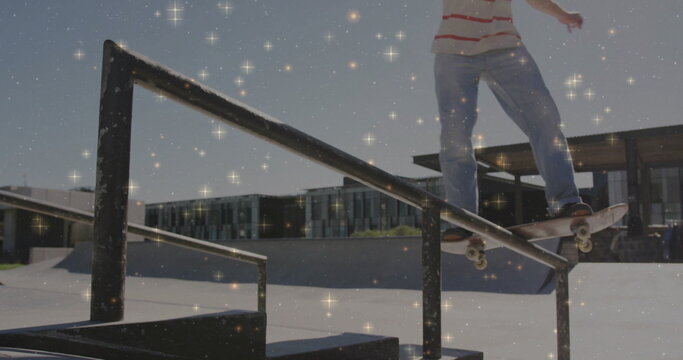 Grinding skateboarder in striped shirt at skatepark rails, ramps and glass building, copy space