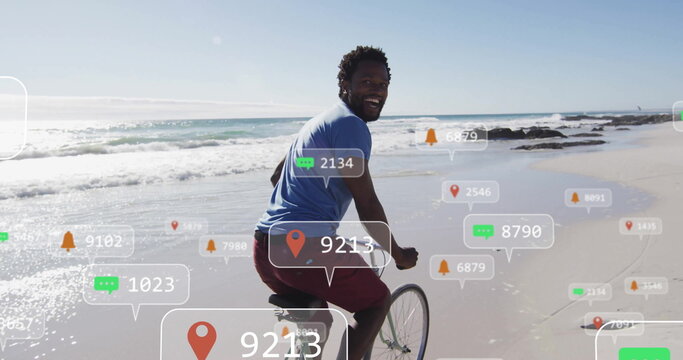 Man in blue t-shirt and red shorts pedaling bicycle along wet shoreline, with floating overlays - Powered by Adobe