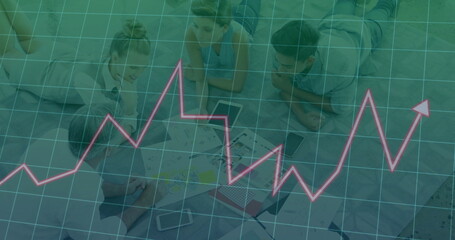 Leaning four coworkers in business attire analyzing charts and laptops in meeting area, with pens