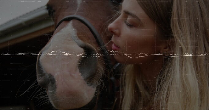 Nuzzling woman leaning toward horse muzzle in stable with wood beams, black halter, digital overlay