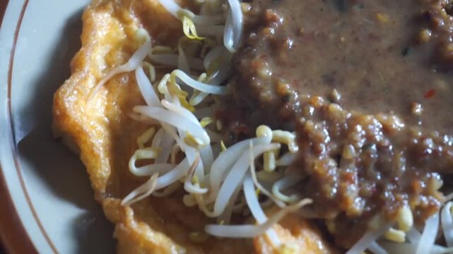 Tofu egg with peanut sauce complete on a plate "Tahu Telur"