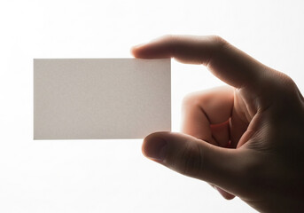 Hand holding blank white business card against bright white background