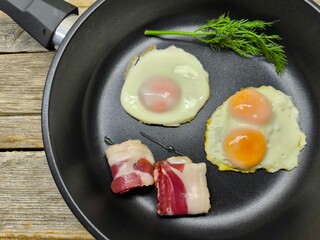 Top view of a skillet breakfast of fried eggs and delicious bacon