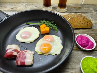 Top view of a skillet breakfast of fried eggs and delicious bacon