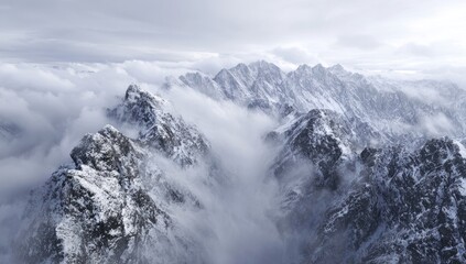 Obraz premium Snowy mountain peaks shrouded in mist (1)