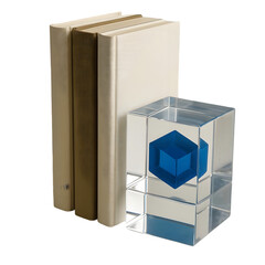 Clear cube with blue geometric shape and stack of books for study and decor