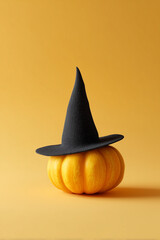 Fototapeta premium A Pumpkin and Witches Hat on Light Yellow Background, Halloween Theme