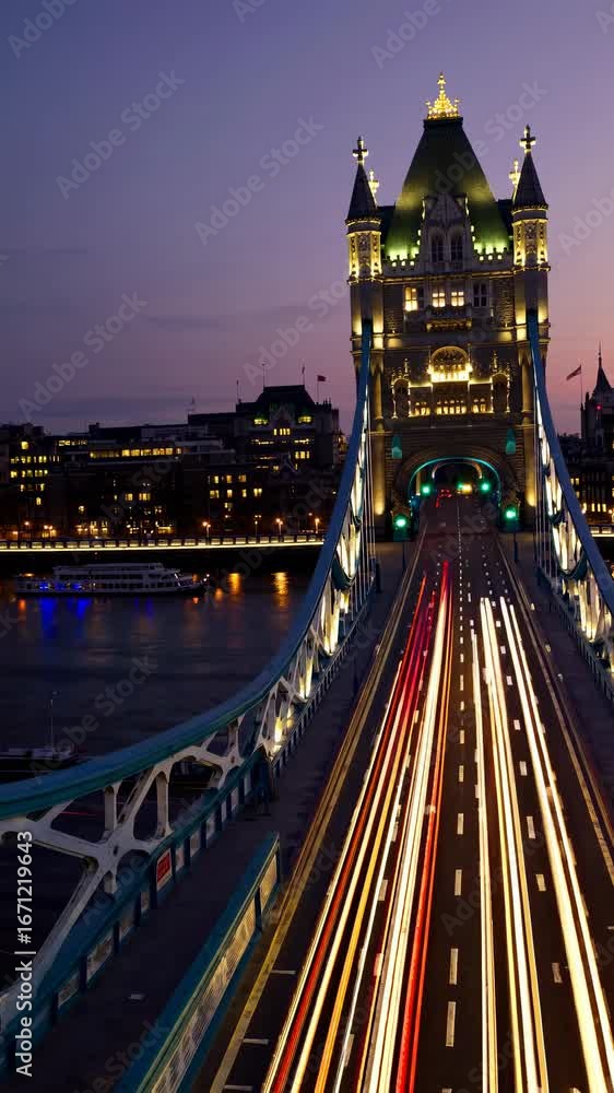 Poster a long-exposure video captures tower bridge at dusk from a low angle, highlighting light trails and 