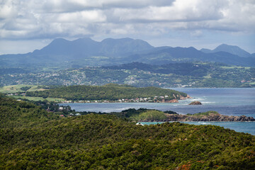 Majestic view of rolling hills with mountains and lush coastline in the distance