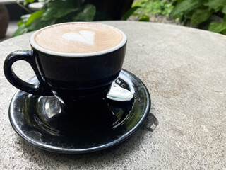 Aromatic Heart-Shaped Latte Art in a Black Cup, Enjoying a Coffee Break Outdoors