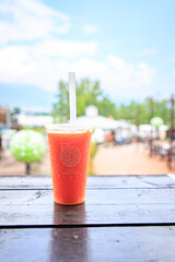 A refreshing melon smoothie on an outdoor wooden table