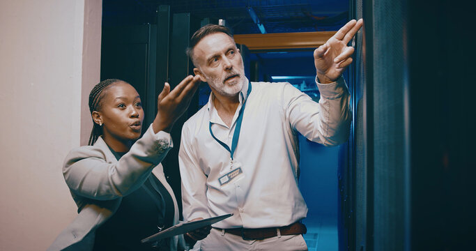 People, programming and tablet in server room, pointing and problem solving with inspection. IT specialist, technical support and employees with hardware upgrade, cooperation and cyber security