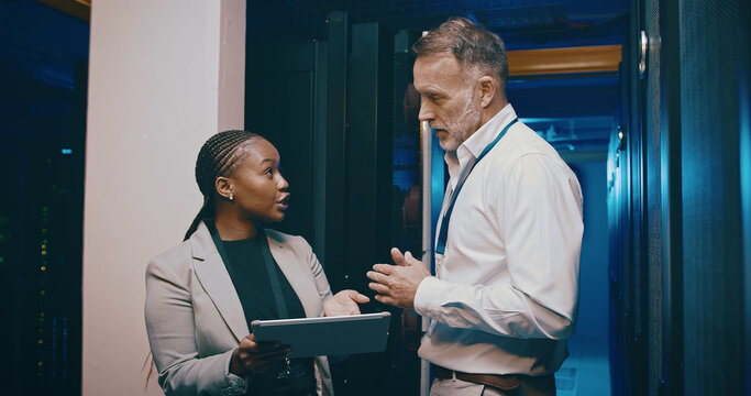 Tablet, team and people in data center for discussion, cloud computing or IT training with intern. Collaboration, tech or engineer in server room for planning maintenance, backup or help with manager - Powered by Adobe