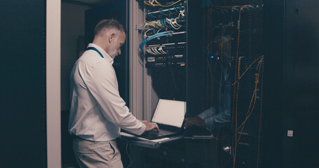 Update, technician and laptop with man in server room for hosting database, inspection and...