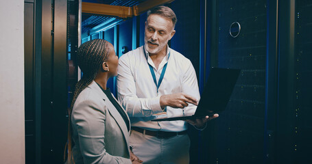 Cybersecurity, laptop and maintenance with people in data center together for network upgrade....