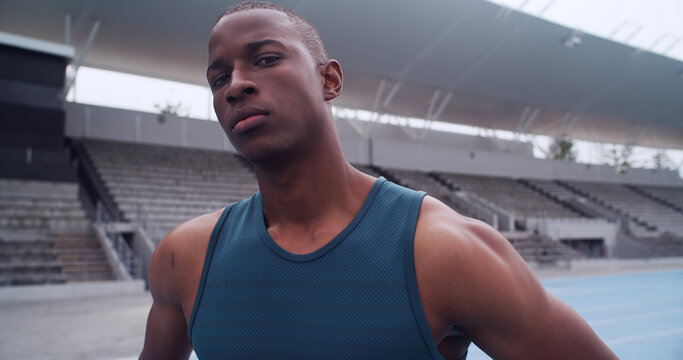 Black man, runner and portrait at stadium for sports competition, athlete or fitness. Training, serious and confident person outdoor for running, workout and track for marathon and wellness - Powered by Adobe
