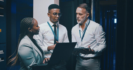 Man, laptop and team with solution in server room with cybersecurity, system or collaboration. Programmer, tech and group with insight for problem solving, assessment or IT maintenance at data center