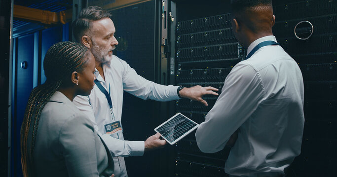 Man, tablet and team with maintenance in server room with cybersecurity, system check or collaboration. Programmer, tech and group with advice for programming, review or IT solution at data center