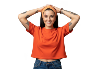 Young woman with tattoos wearing an orange tshirt and hairband, smiling and holding her hands on her head, isolated on transparent background
