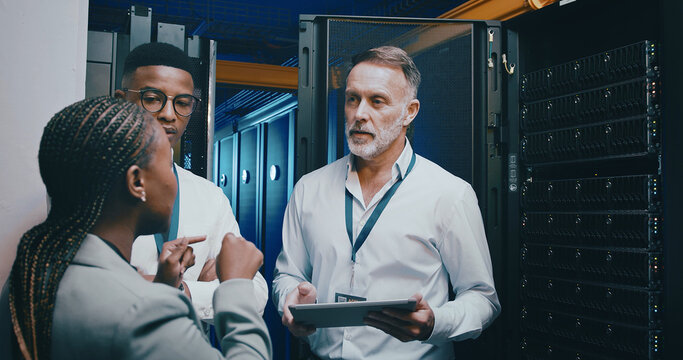 Server room, training and people on tablet for cybersecurity, diagnostics test or maintenance. IT team, meeting and workers with boss on digital tech for network, online database or technical support - Powered by Adobe