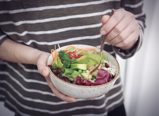 Fresh, nutritious salad held in a person's hands. A balanced meal for a healthy and mindful lifestyle.