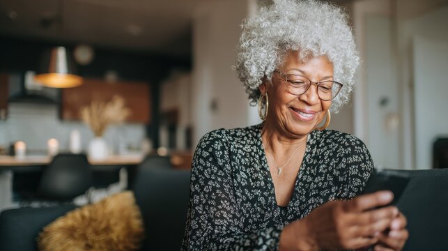 mature african woman using smartphone app for creating playlist with rock music  senior female having fun with mobile phone technology  tech and joyful elderly lifestyle concept  focus on face no log