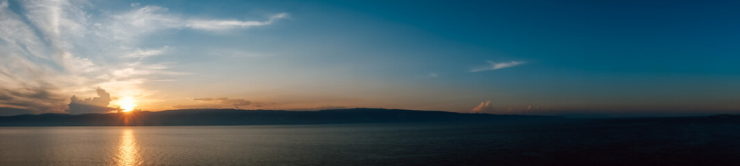 breathtaking view sunset illuminating sky with warm hues as clouds gather above serene body water,...