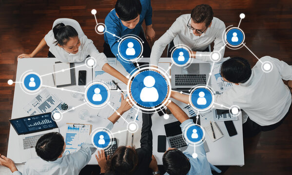 Engaging scene of diverse professionals collaborating at a conference table, utilizing technology and networking concepts, illustrating effective teamwork and innovation. Amity - Powered by Adobe