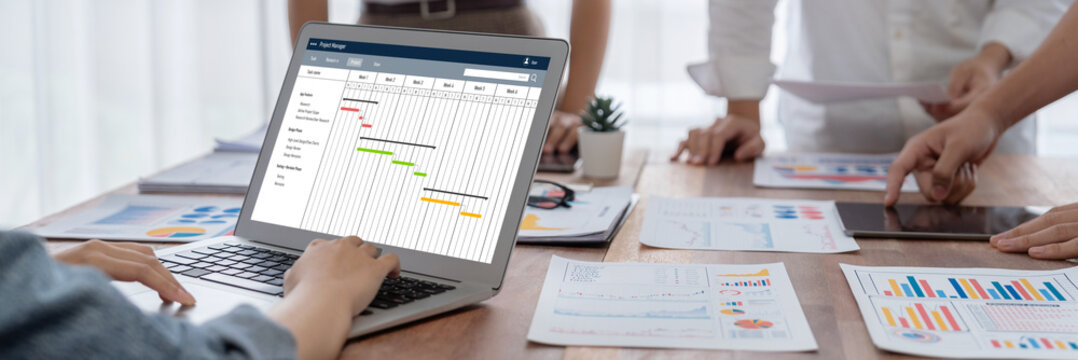Project planning software for brisk business project management on the computer screen showing timeline chart of the team project