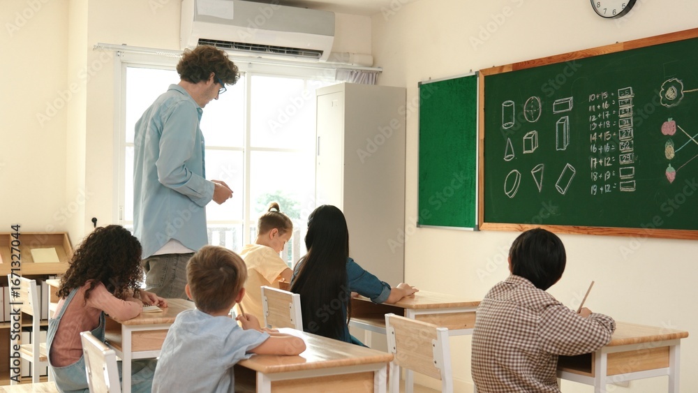 Poster skilled teacher walking at classroom while looking at student homework. professional instructor chec