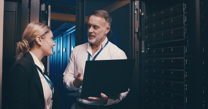 Laptop, collaboration and team of engineers in server room for technical support, database or cybersecurity. Computer, discussion and people with system upgrade in data center for network programming