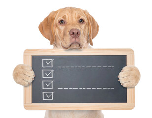 Yellow Labrador Retriever holding a small chalkboard checklist, looking up with expressive eyes.
