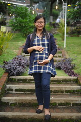happy pregnant woman standing in the park