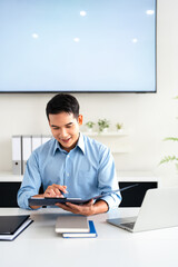 Young man businessman accountant looks at the papers reviews documents, business agreements, bills at desk in the office.