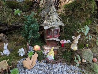 Public children’s garden filled with fairy tale characters, animals, and moss-covered houses, creating a magical storybook atmosphere in a natural outdoor setting.