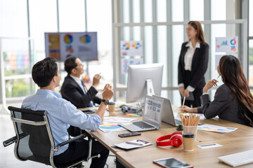 Female executive presents to her team in a contemporary office setting, where an asian businesswoman guides colleagues through strategic planning and business discussion, representing corporate leader