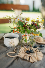 Delicate Floral Arrangement and Berries on a Rustic Table Setting