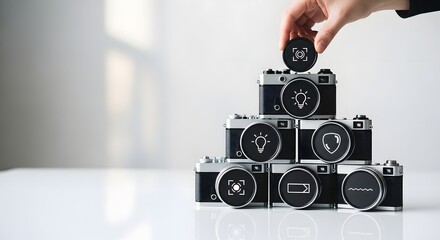 Conceptual representation of building a complete photography solution, with a hand placing the final feature icon on a pyramid of cameras