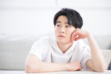 頬杖をつく考える表情の男性のクローズアップ