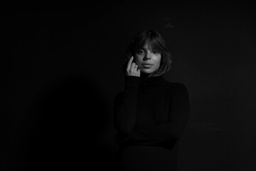 Obraz premium Low key black and white portrait of young woman in black sweater