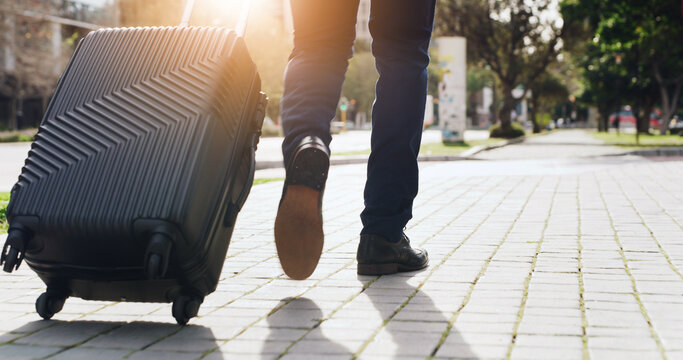 Legs, luggage and steps with businessman in city for commute, journey or travel from back. Flare, suitcase and walking with feet of employee outdoor on sidewalk for trip to international destination - Powered by Adobe