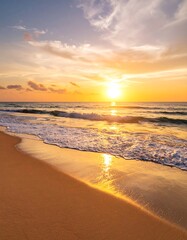 Golden sunset over tranquil ocean waves gently lapping a sandy beach
